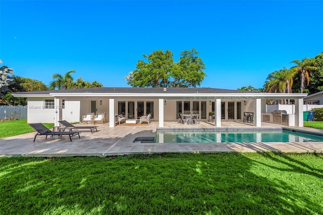 rear view of property with a lawn and a patio