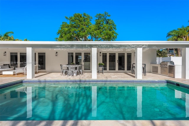 view of pool featuring area for grilling, a grill, and a patio