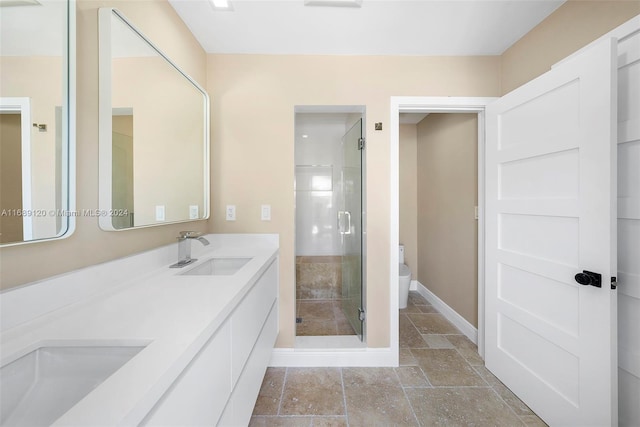 bathroom with vanity, toilet, and a shower with door