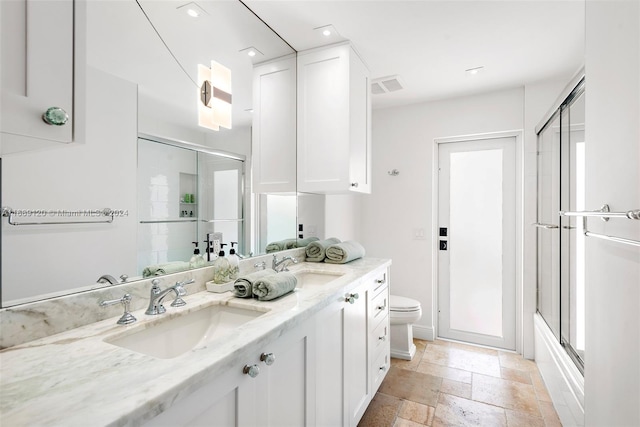 full bathroom with vanity, combined bath / shower with glass door, and toilet