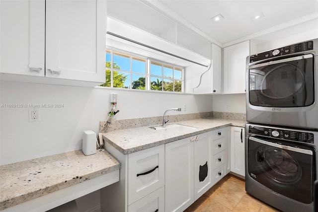 laundry room featuring stacked washer and clothes dryer, cabinets, sink, and light tile patterned flooring