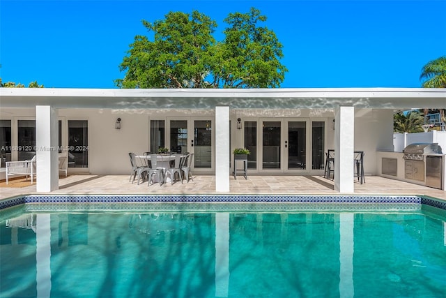 view of swimming pool featuring a patio area, area for grilling, and a grill