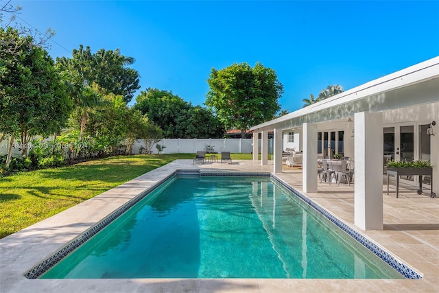 view of pool with a patio and a yard