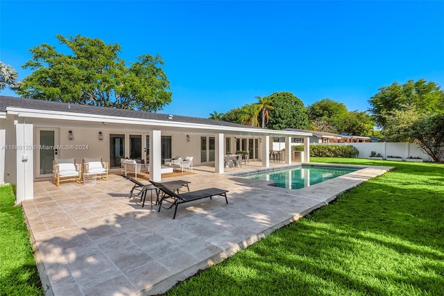 back of house featuring a lawn, outdoor lounge area, a fenced in pool, and a patio