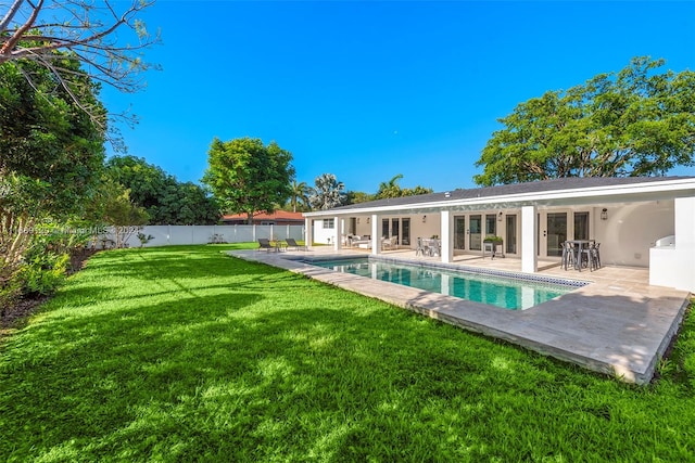 back of house featuring a fenced in pool, a patio, and a yard