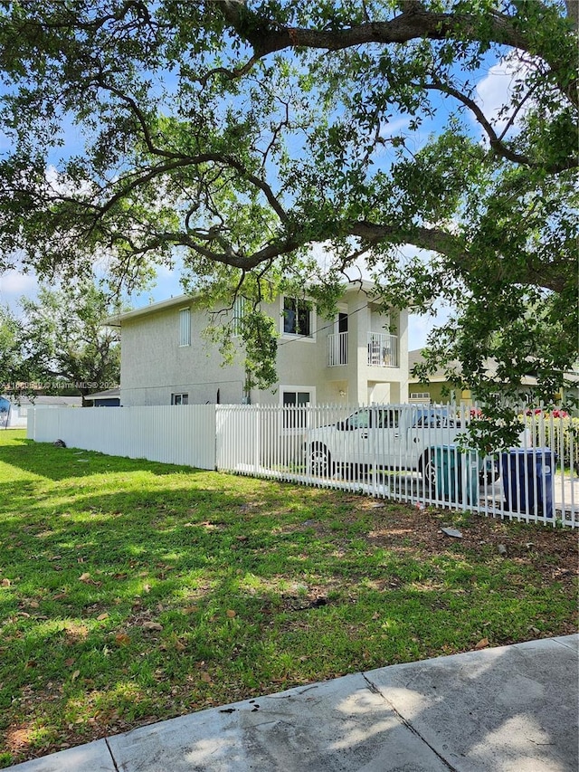 exterior space with a front yard and a balcony