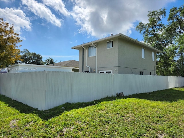 view of side of home with a yard