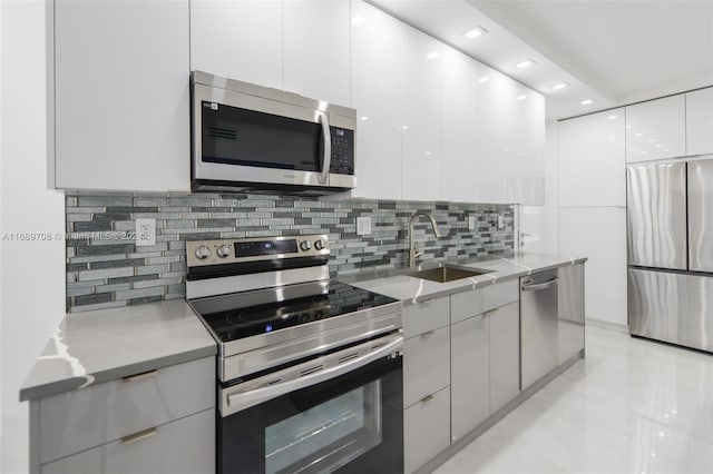 kitchen with white cabinets, appliances with stainless steel finishes, sink, and tasteful backsplash