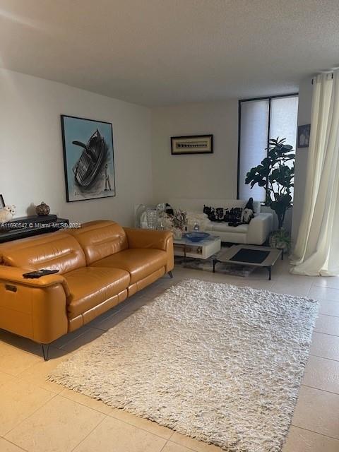 living room with a textured ceiling and light tile patterned floors