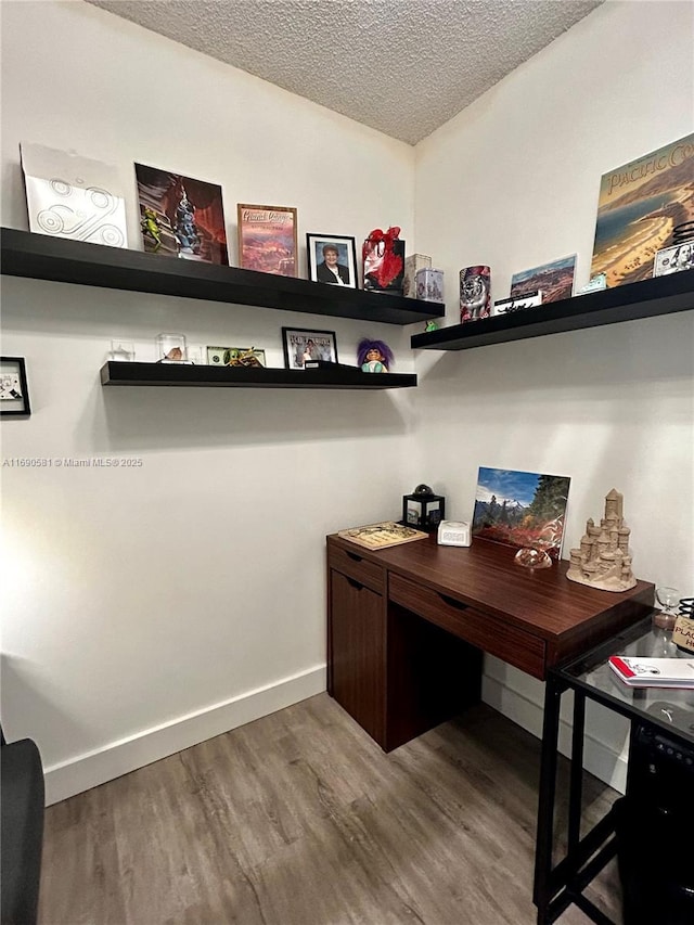 office with wood-type flooring and a textured ceiling