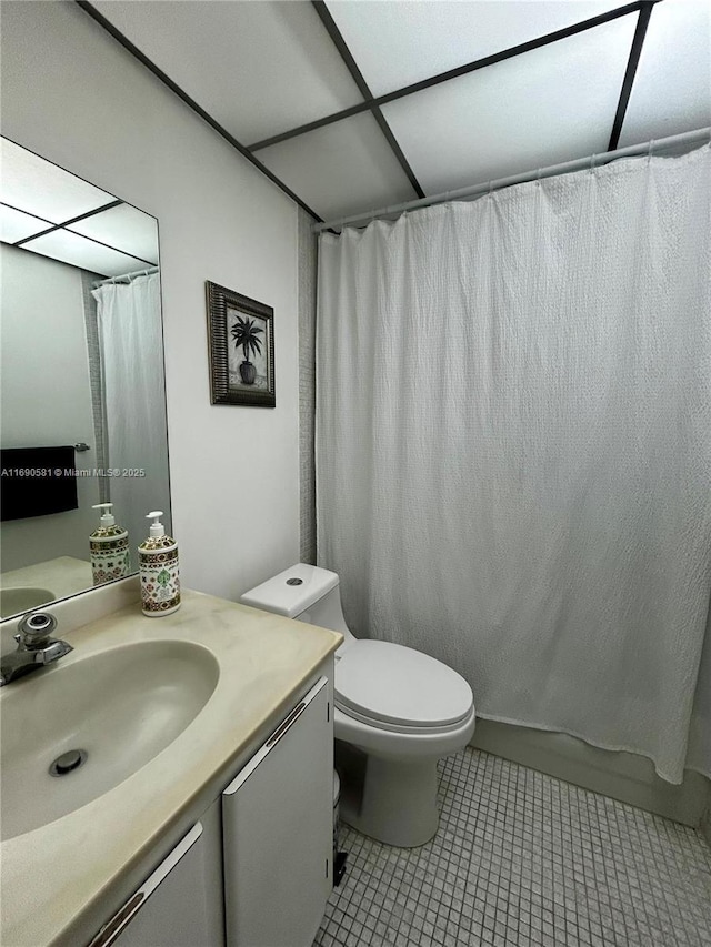 bathroom featuring toilet, vanity, tile patterned floors, and curtained shower