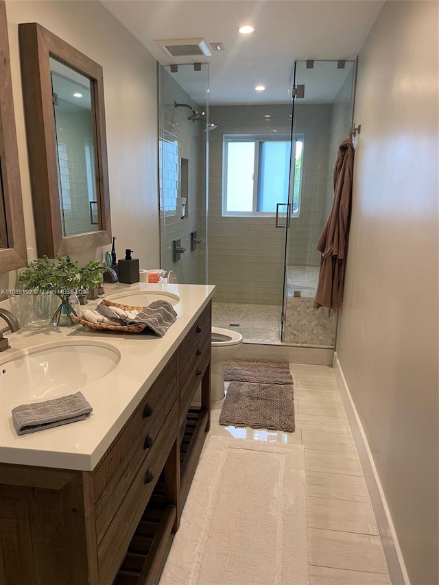 bathroom with toilet, tile patterned floors, vanity, and a shower with door