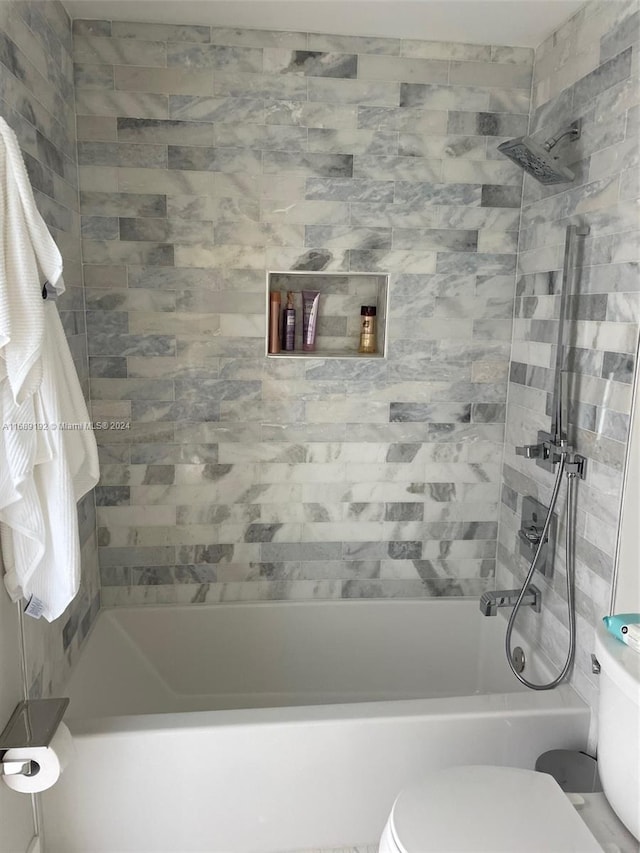 bathroom featuring toilet and tiled shower / bath combo