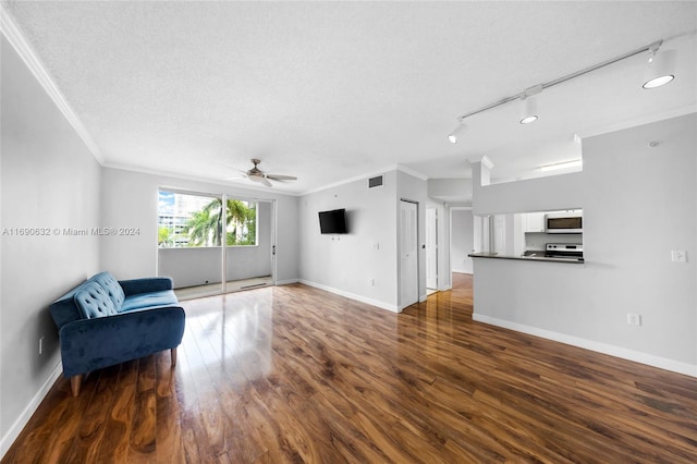 unfurnished room featuring a textured ceiling, track lighting, dark hardwood / wood-style flooring, and ornamental molding