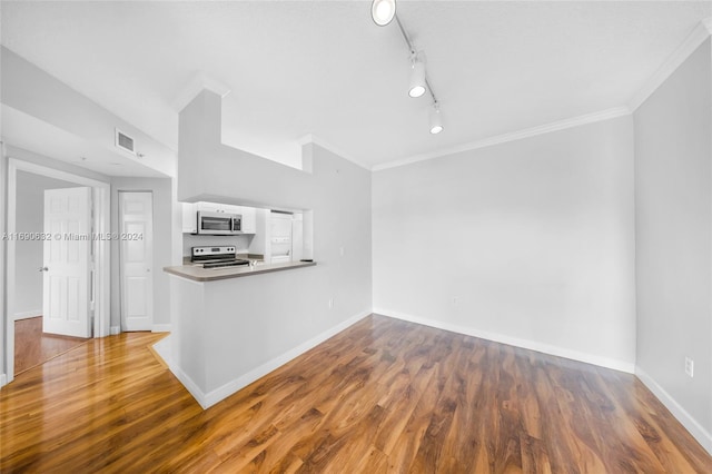 interior space with white cabinets, kitchen peninsula, stainless steel appliances, and dark hardwood / wood-style floors