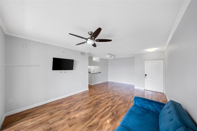 unfurnished living room with ornamental molding, hardwood / wood-style floors, ceiling fan, and a textured ceiling