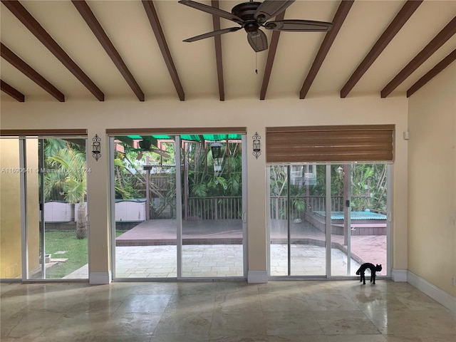 interior space with beamed ceiling and a wealth of natural light