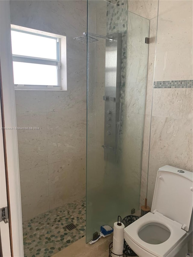 bathroom with tiled shower and toilet