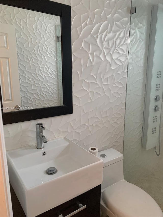 bathroom with vanity, tasteful backsplash, and toilet