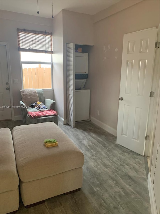 living room with hardwood / wood-style floors and stacked washer / drying machine