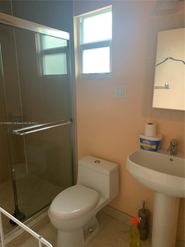 bathroom featuring walk in shower, toilet, and tile patterned floors