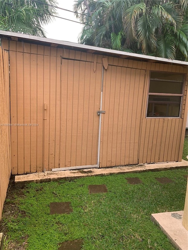 view of outbuilding featuring a lawn