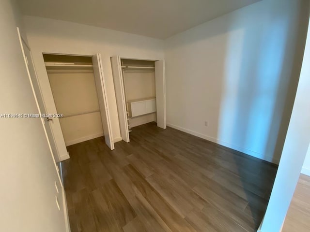 unfurnished bedroom with dark hardwood / wood-style flooring