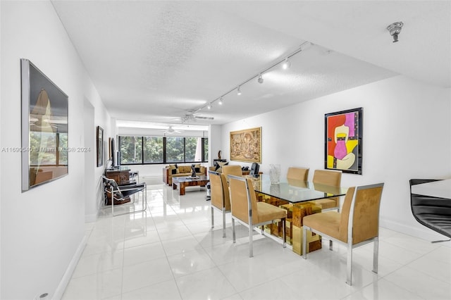 dining area featuring light tile patterned flooring, a textured ceiling, ceiling fan, and rail lighting