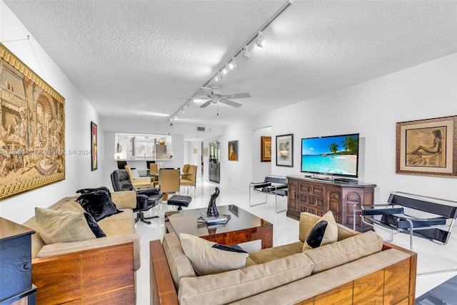 living room featuring track lighting, a textured ceiling, and ceiling fan