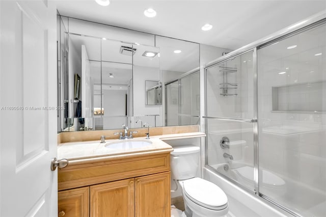 full bathroom with toilet, combined bath / shower with glass door, and vanity