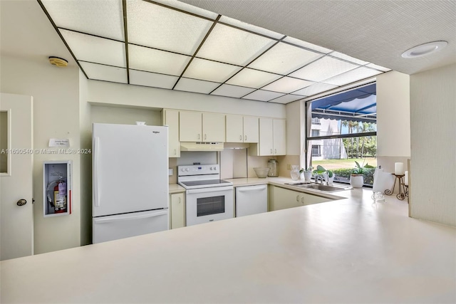 kitchen with white appliances, sink, and white cabinets