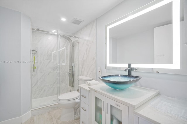 bathroom with walk in shower, vanity, and toilet