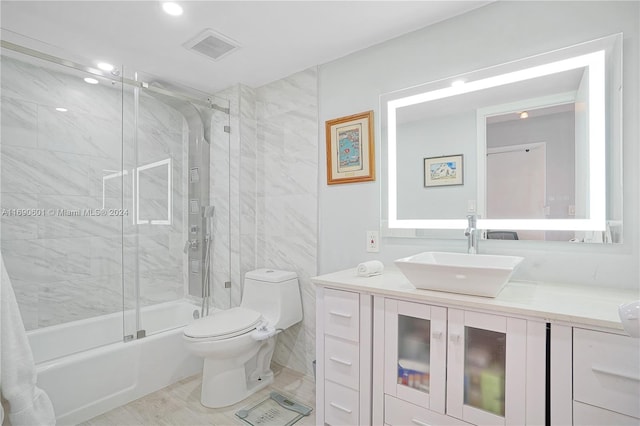 full bathroom with vanity, toilet, and enclosed tub / shower combo