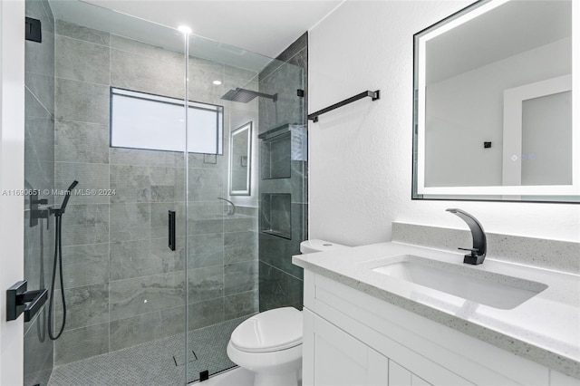 bathroom featuring walk in shower, vanity, and toilet