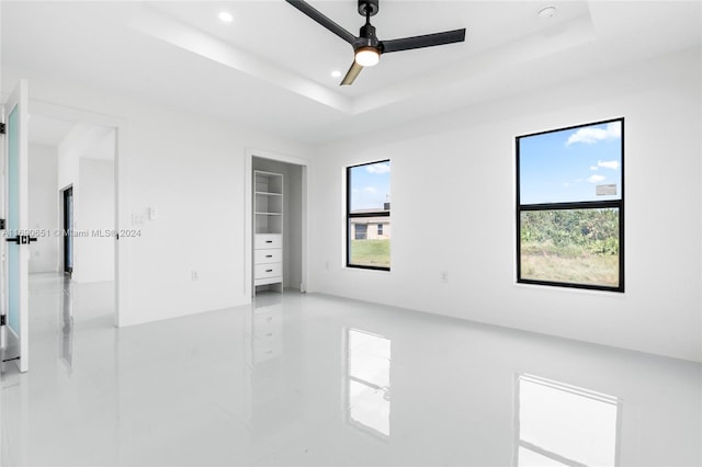 empty room with a tray ceiling and ceiling fan