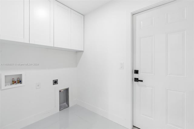 clothes washing area with cabinets, hookup for a washing machine, hookup for an electric dryer, and light tile patterned floors