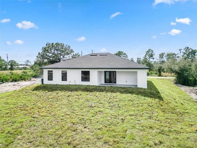 rear view of house with a patio and a yard