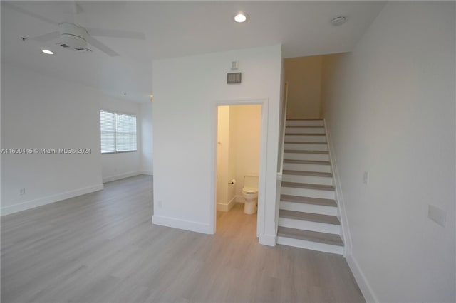 stairway featuring hardwood / wood-style flooring and ceiling fan