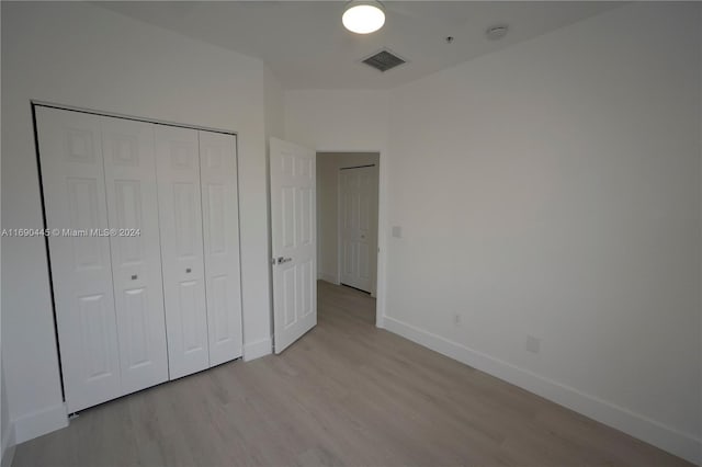 unfurnished bedroom featuring light hardwood / wood-style floors and a closet