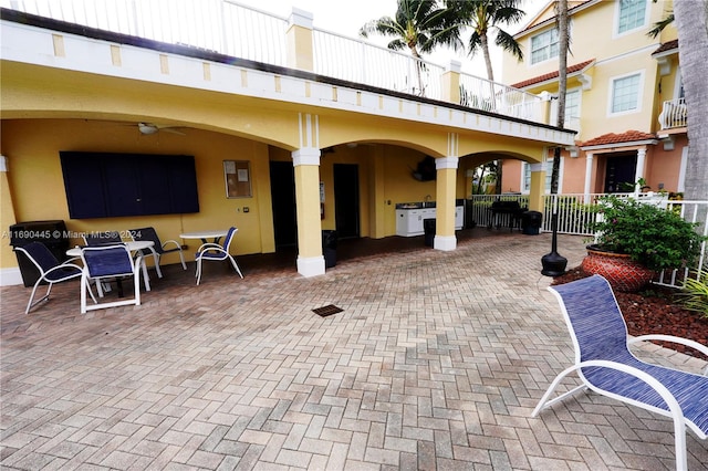 view of patio with ceiling fan and a balcony