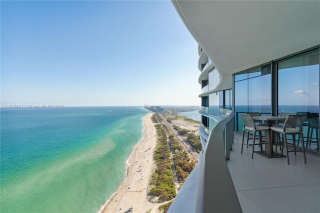 balcony featuring a water view and a beach view