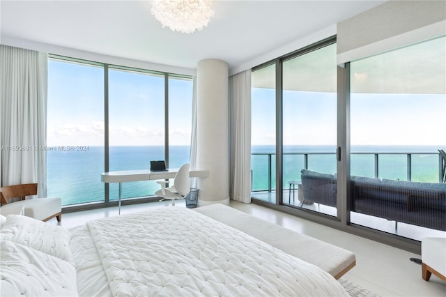 bedroom featuring a water view and a wall of windows