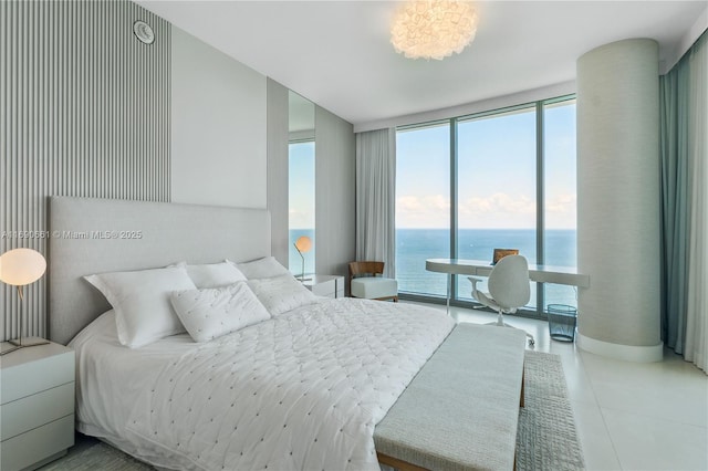 bedroom featuring a water view, a wall of windows, and light tile patterned floors