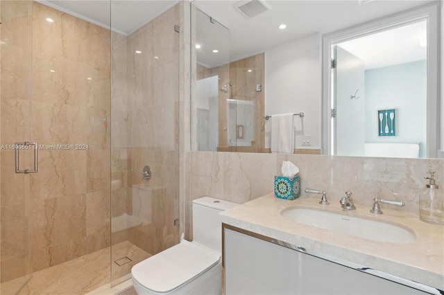 bathroom with an enclosed shower, tile walls, toilet, vanity, and decorative backsplash