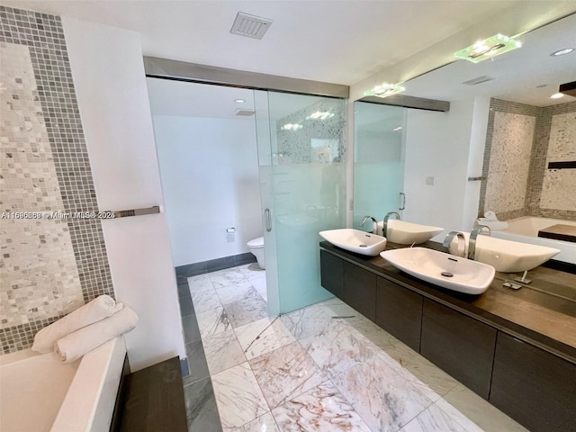 bathroom with visible vents, a sink, a bath, and double vanity