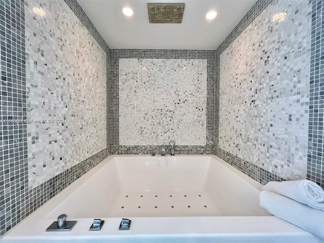 bathroom featuring a washtub and tile walls