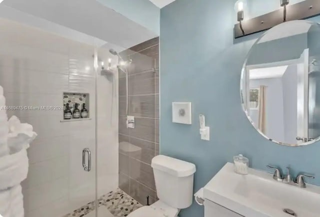 bathroom featuring walk in shower, vanity, and toilet