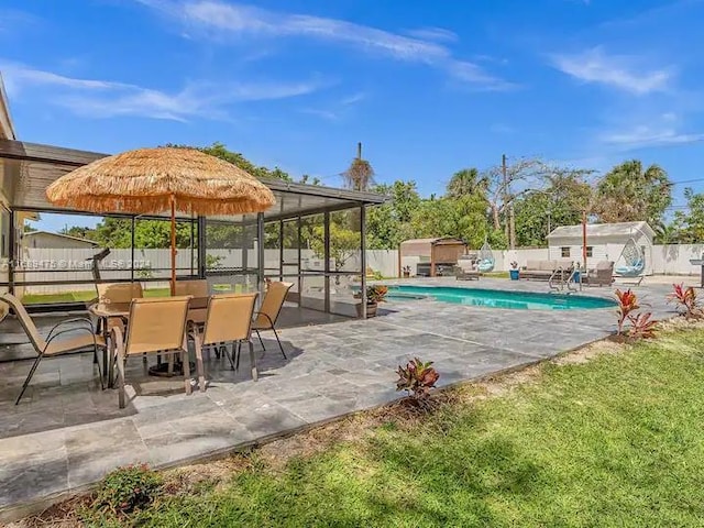 view of swimming pool with a patio, a lawn, and a storage shed