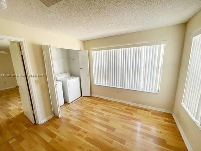 laundry area with plenty of natural light and light hardwood / wood-style flooring