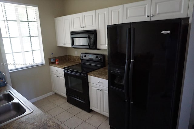 kitchen with white cabinets, black appliances, light tile patterned floors, and sink